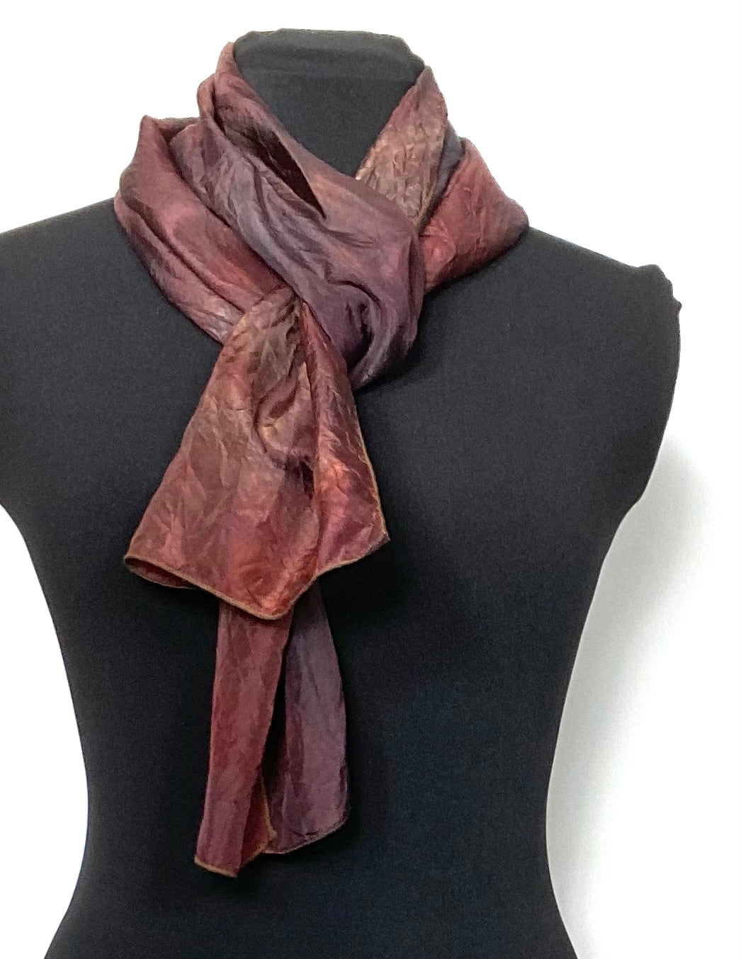 Brown silk dyed scarf draped over a black mannequin on a white background