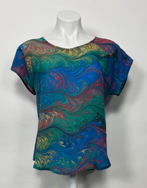 Colorful marbled top on a mannequin against a white background