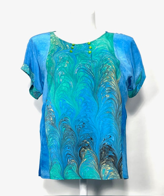 Blue and green marbled patterned top on a mannequin against a white background