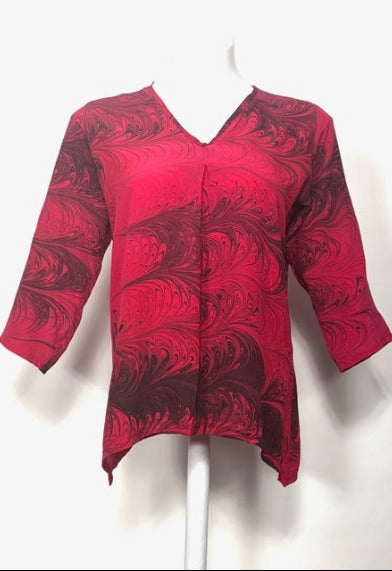 Red marbled silk blouse on a white mannequin