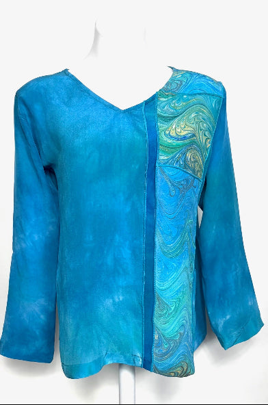 Hand dyed blue and jade blouse with a marbled side panel on a white background