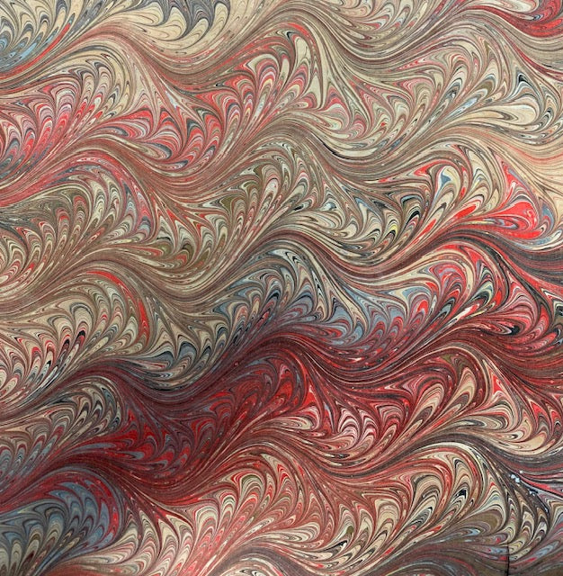 Marbled silk closeup with swirling patterns in red, brown, and beige.