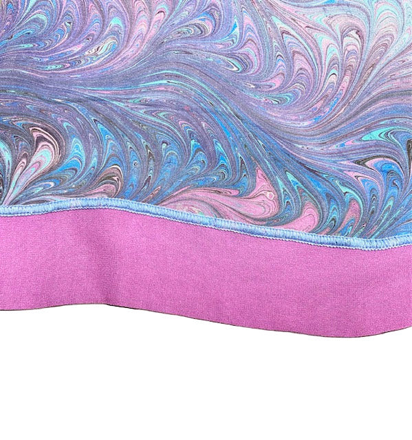 Marbled fabric with pink and blue swirls on a white background