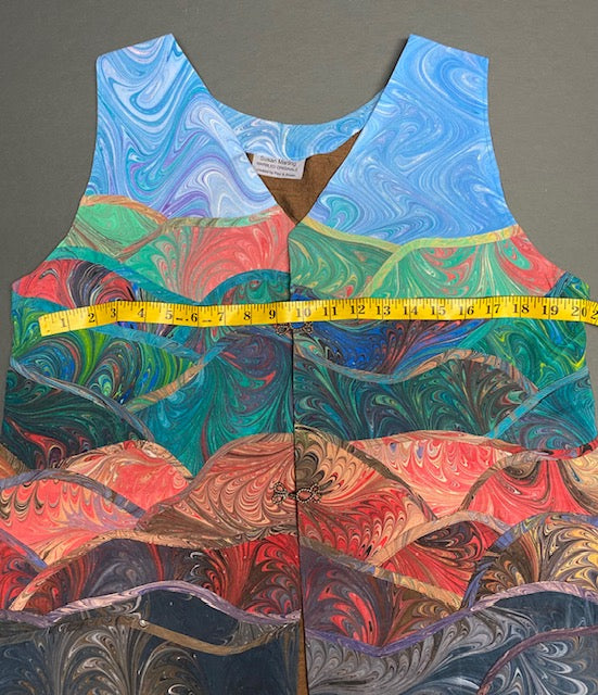 Front of marbled silk vest with a measuring tape showing bust measurement