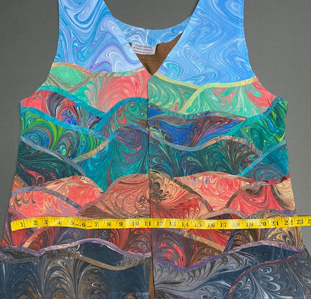 Marbled silk art vest laid out with measuring tape at the hip