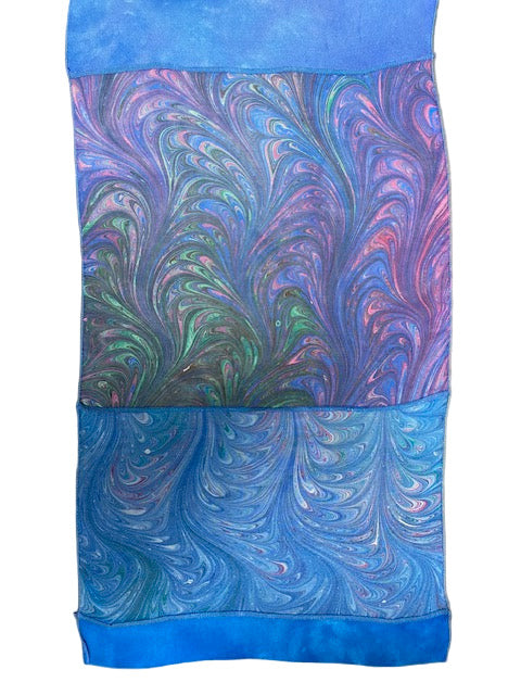 closeup of Marbled silk scarf with blue and purple swirls on a white background