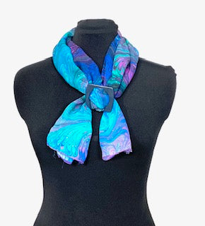 Colorful hand marbled silk scarf in blue, green violet on a black mannequin against a white background