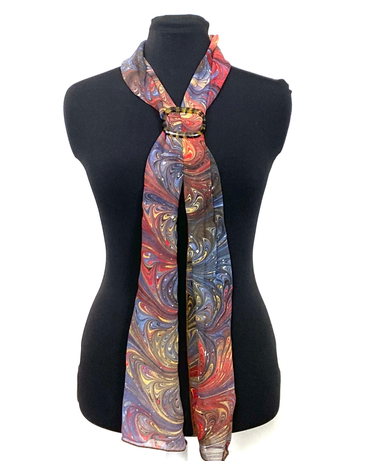 Colorful marbled silk scarf on a black mannequin against a white background