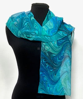 Mannequin wearing a blue and green marbled silk scarf on a white background