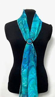 Turquoise marbled silk scarf on a black mannequin against a white background
