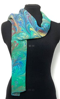 Colorful marbled scarf on a black mannequin against a white background