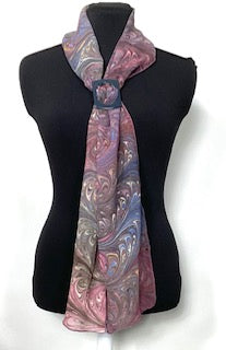 Scarf with a mauve and brown feathered pattern draped over a black mannequin on a white background