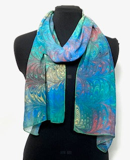 Colorful marbled silk scarf on a mannequin against a white background