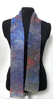 Colorful marbled silk scarf on a mannequin against a white background