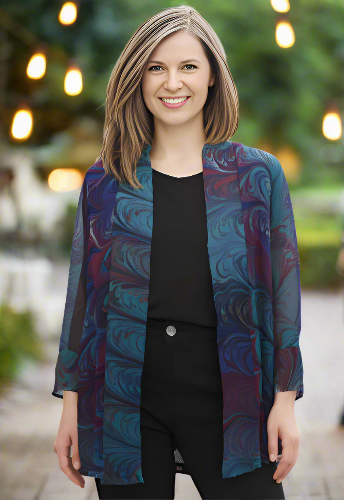 Woman wearing a marbled silk blue and purple jacket over a black top outdoors.