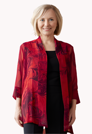Woman wearing a red marbled sheer jacket and black pants in an indoor setting