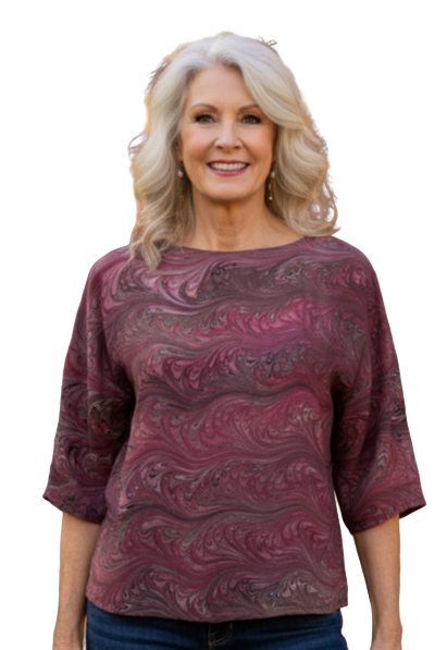 Woman wearing a marbled silk top in cranberry and brown colors