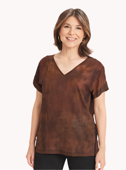 Woman wearing a brown tie-dye shirt and black pants on a white background