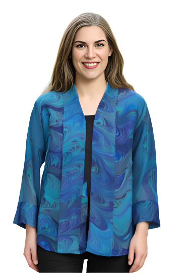 Woman wearing a hand marbled silk blue jacket and black pants standing on a stone pathway.