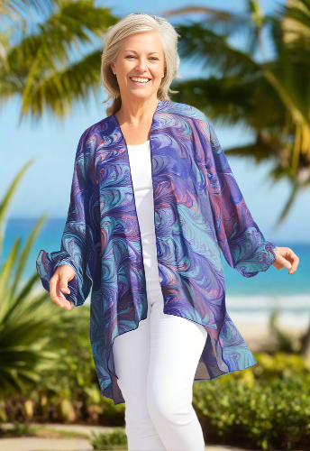 Woman wearing a colorful kimono-style wrap over a white outfit on a white background