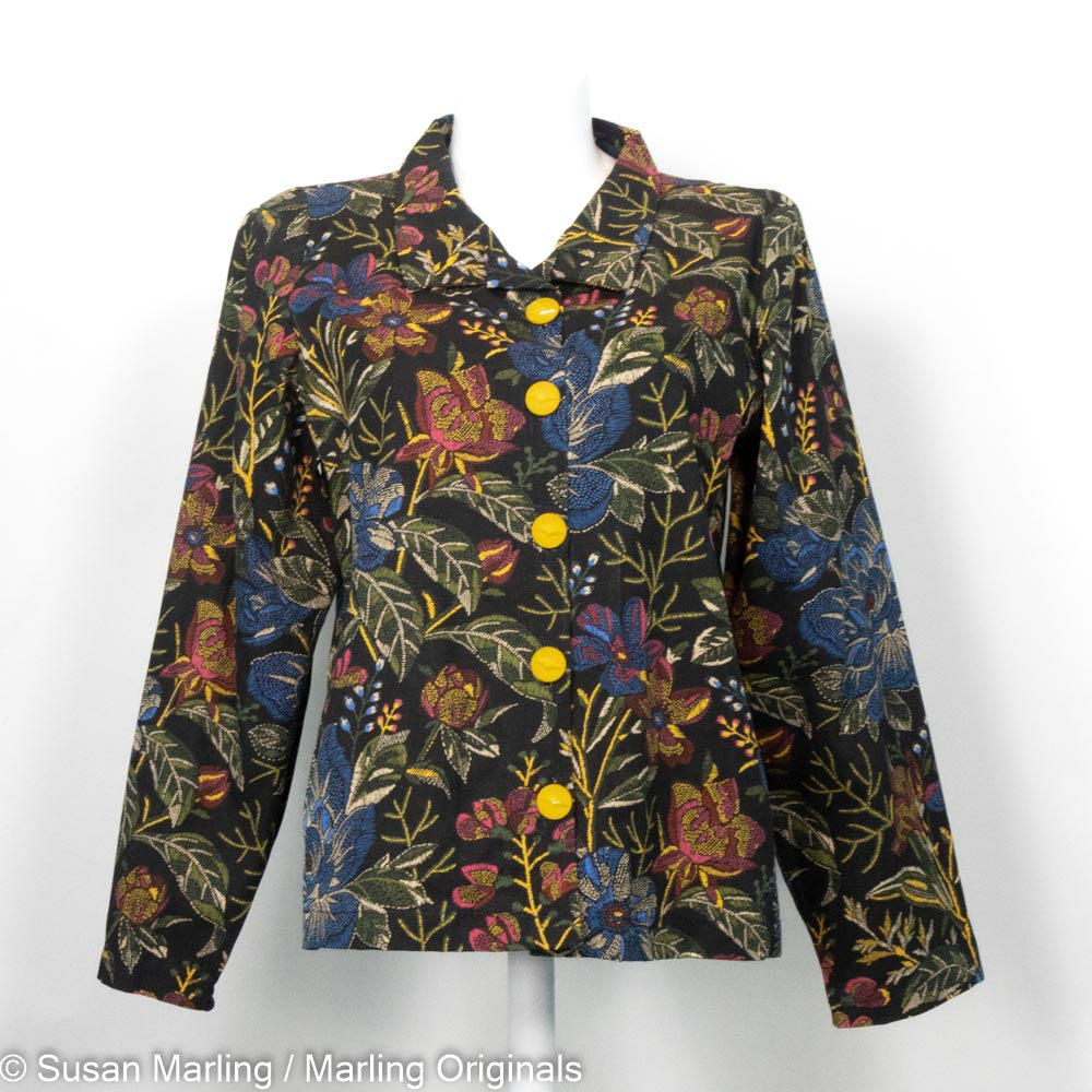 Black tapestry style jacket with gold and red flowers on a mannequin against the white background