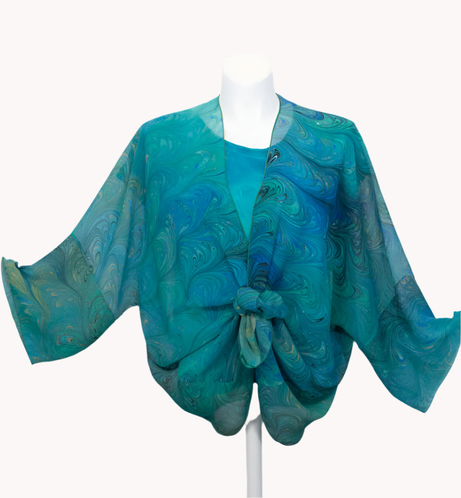 Blue patterned wrap/jacket tied in front on a white mannequin against a white background