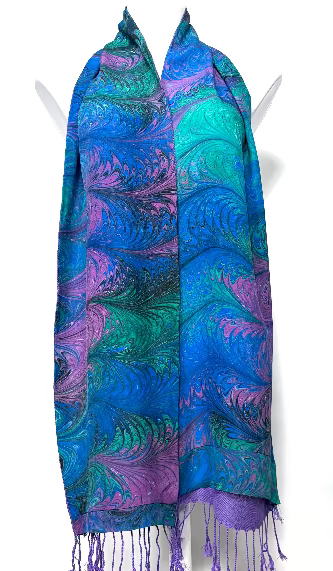 Colorful marbled silk scarf in jewel tones on a mannequin