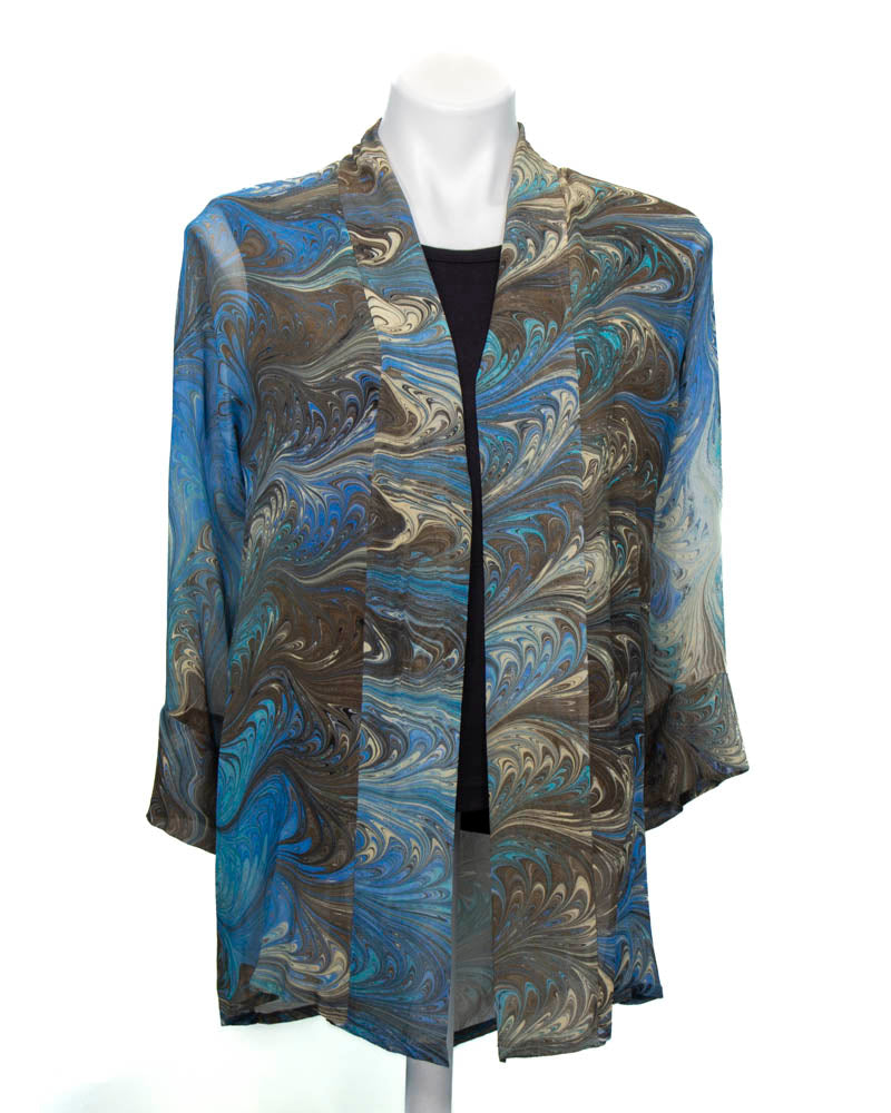 A silk kimono jacket with a marbled pattern in blue, black, cream, and cocoa colors, displayed on a mannequin.
