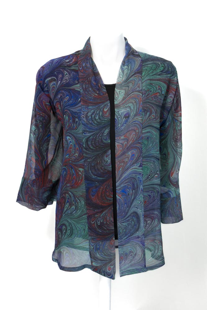 A sheer chiffon silk kimono with marbled print in green, purple, red blue displayed on a mannequin.