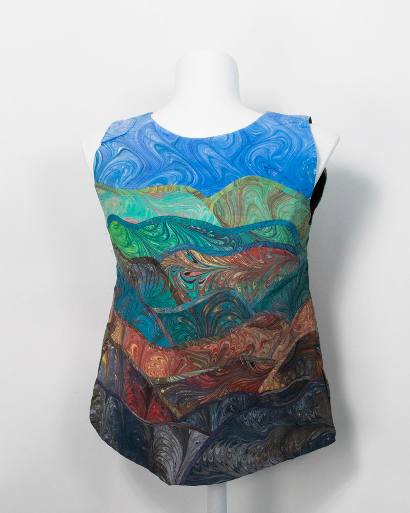 Back of a sleeveless silk vest with intricate marbled pattern and stitching on a white background