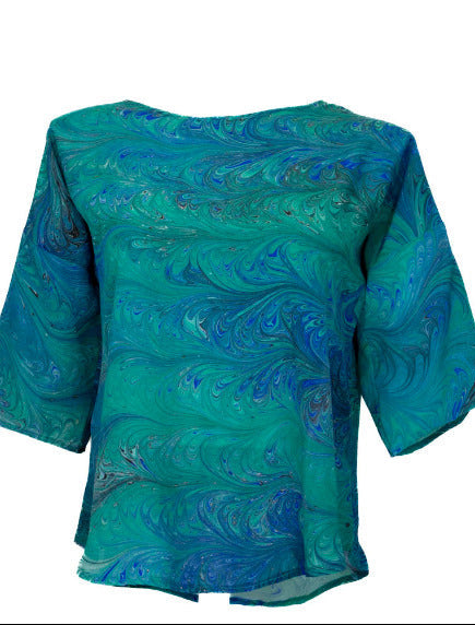 Bright green and blue marbled pattern silk top shown on a mannequin against the white background