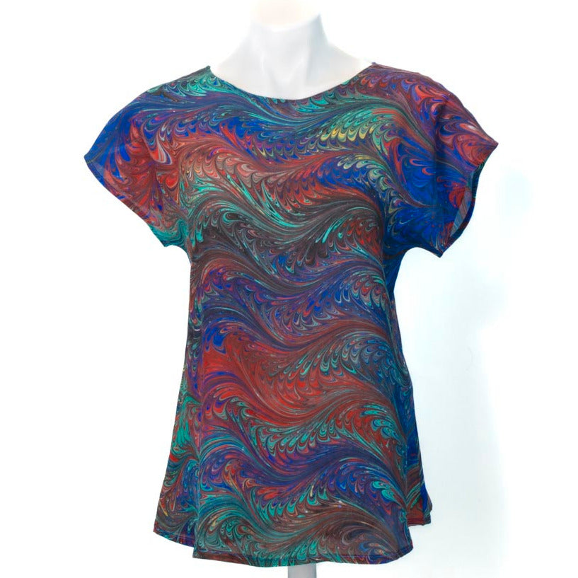 Marble short sleeve silk top with round neck and bright primary colors on a mannequin against the white background
