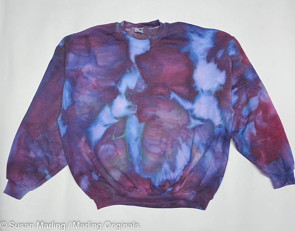 Ice died sweatshirt and blue and purple laying against the white background