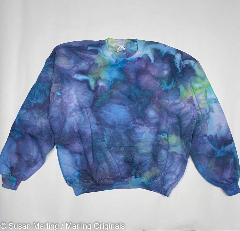 Ice dyed sweatshirt and blue and purple laying against a white background