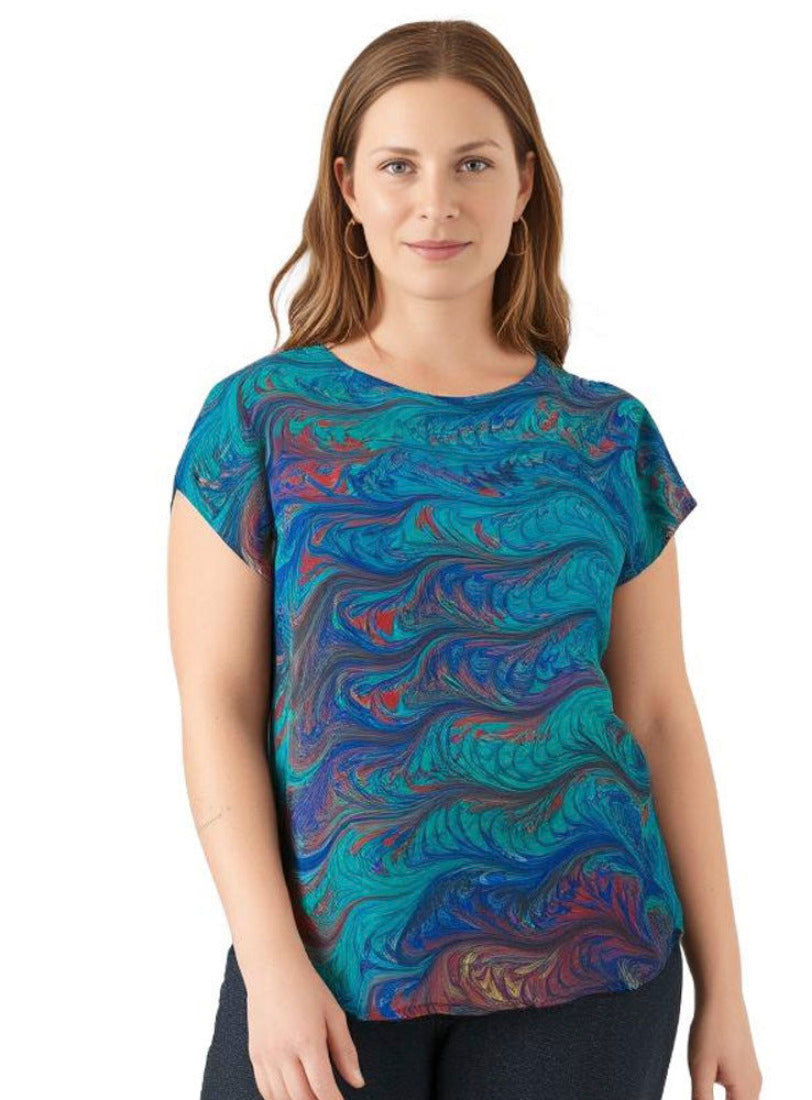 Woman wearing a colorful hand marbled silk shirt on a white background