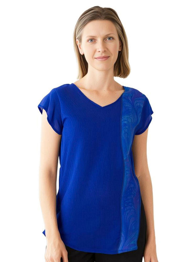 Woman wearing a blue hand dyed silk top with marbled embellishment against a white background