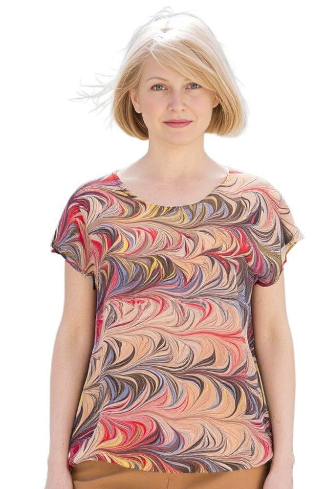 woman wearing a marbled silk blouse in warm golden tones