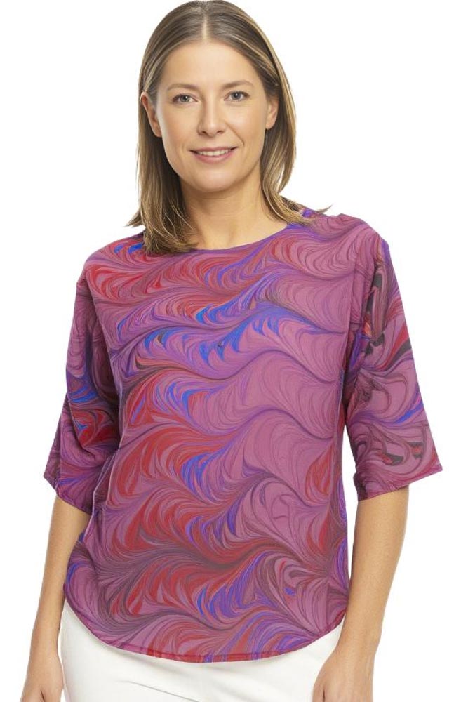 woman wearing twist marbled silk top in red, pink and light blue