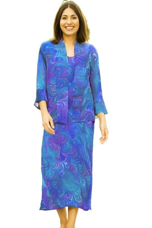 woman wearing long marbled silk dress with matching jacket in blues, purples