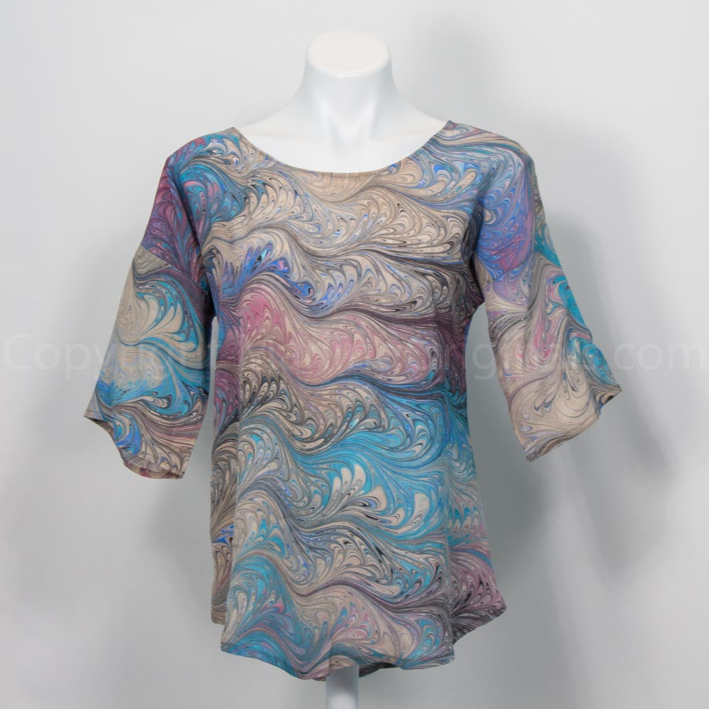 Marble silk blouse in tan teal and Mauve on mannequin against white background