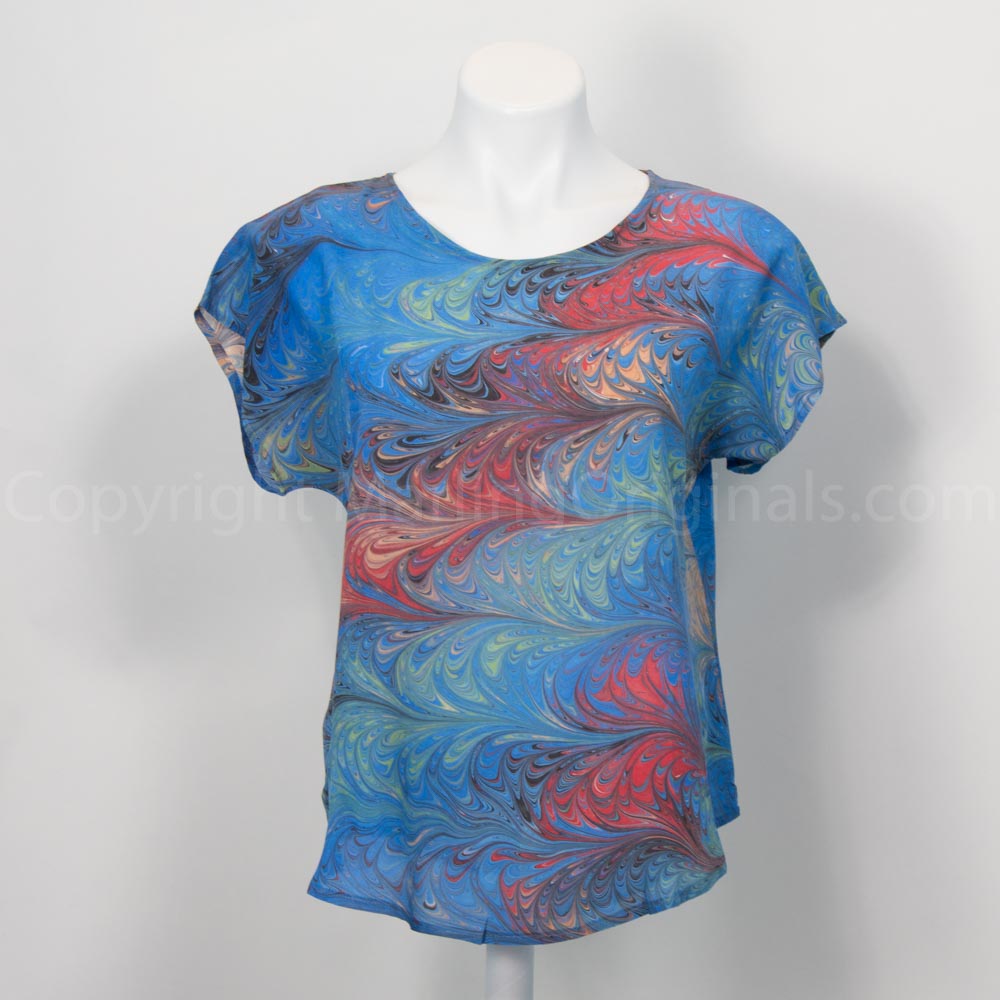 Short sleeve blouse in blue, sienna and red on mannequin against white background