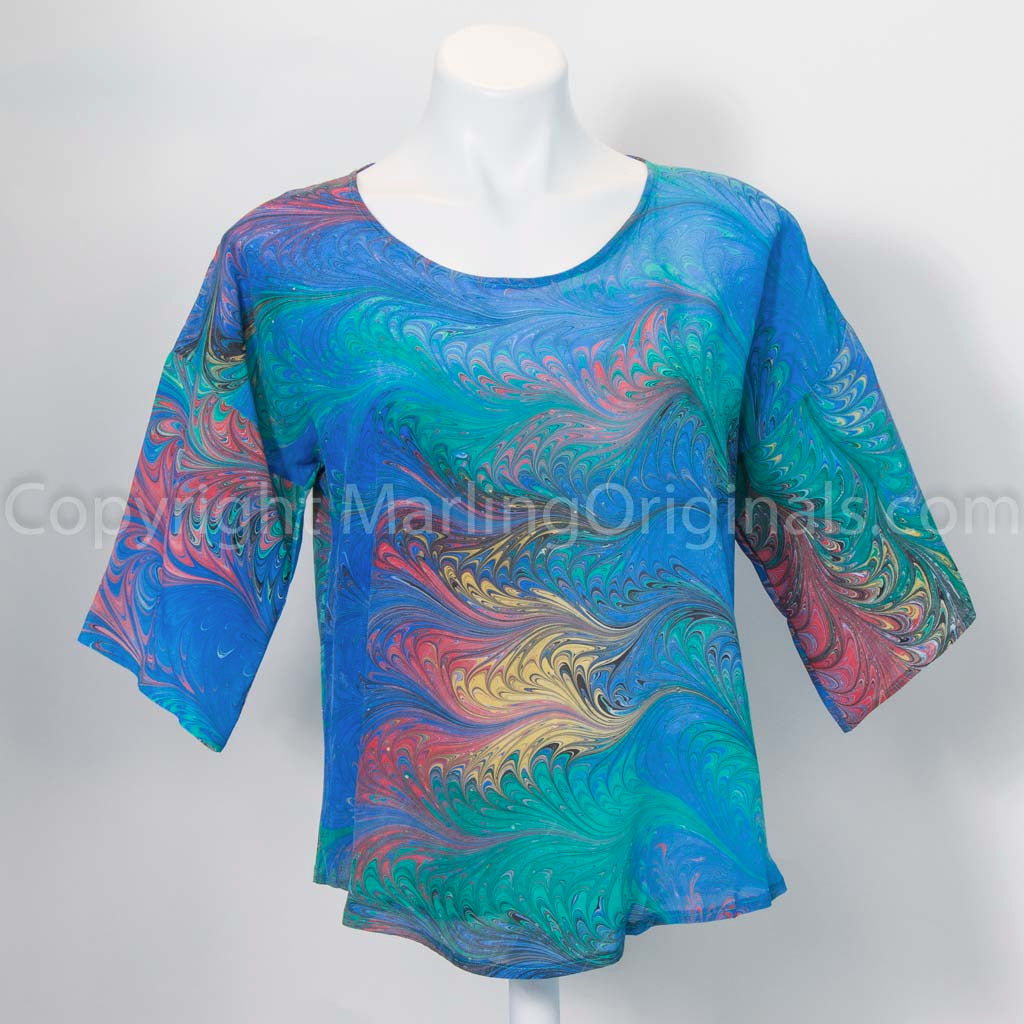 Marbled silk top and blue red gold with round neck and half sleeves on mannequin against the white background