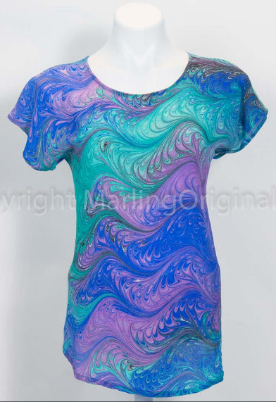 A silk top with a round neckline and short sleeves, featuring a hand-marbled crepe feathered pattern in blue, green, violet, and black tones.