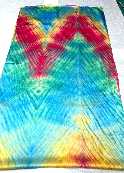 Colorful shibori dyed silk satin scarf with a zigzag pattern on a white background