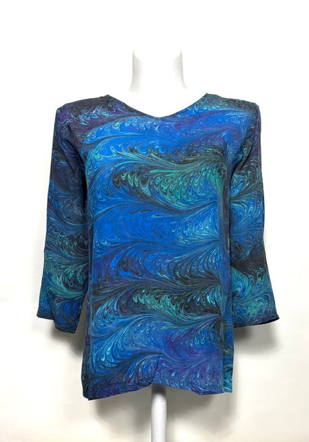 Blue and green marbled silk  top on a mannequin against a white background