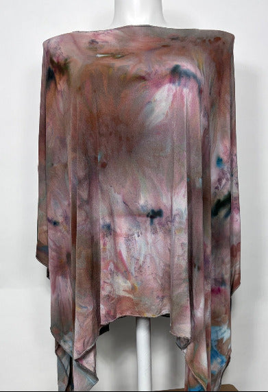 Multicolored poncho draped over a mannequin against a white background