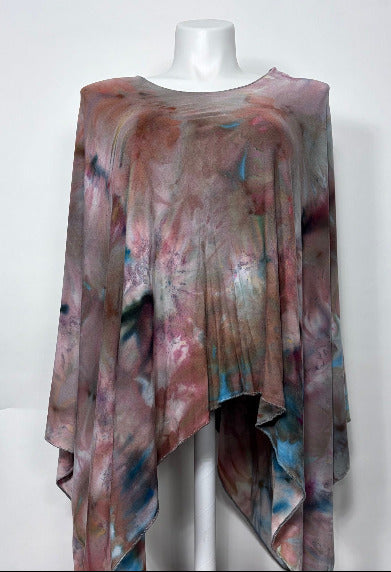 Multicolored knit poncho on a mannequin against a white background