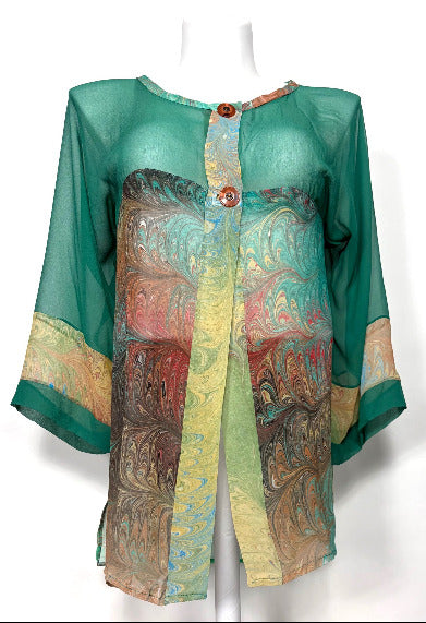 Colorful dyed and marbled silk jacket on a mannequin against a white background
