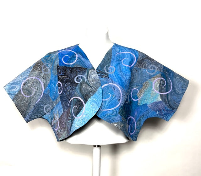 Blue marbled and quilted bolera  jacket on a white stand