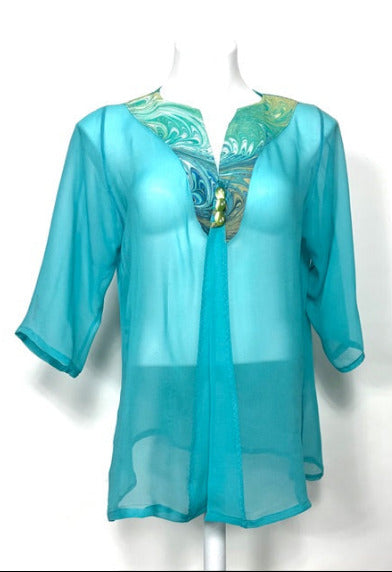 Aqua sheer cover-up with marbled silk neck area on a mannequin